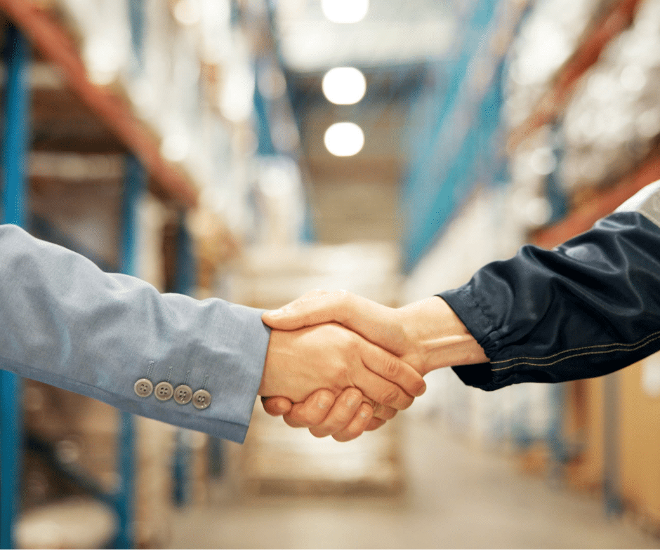 stretta di mano tra persone all'interno di un'area produttiva